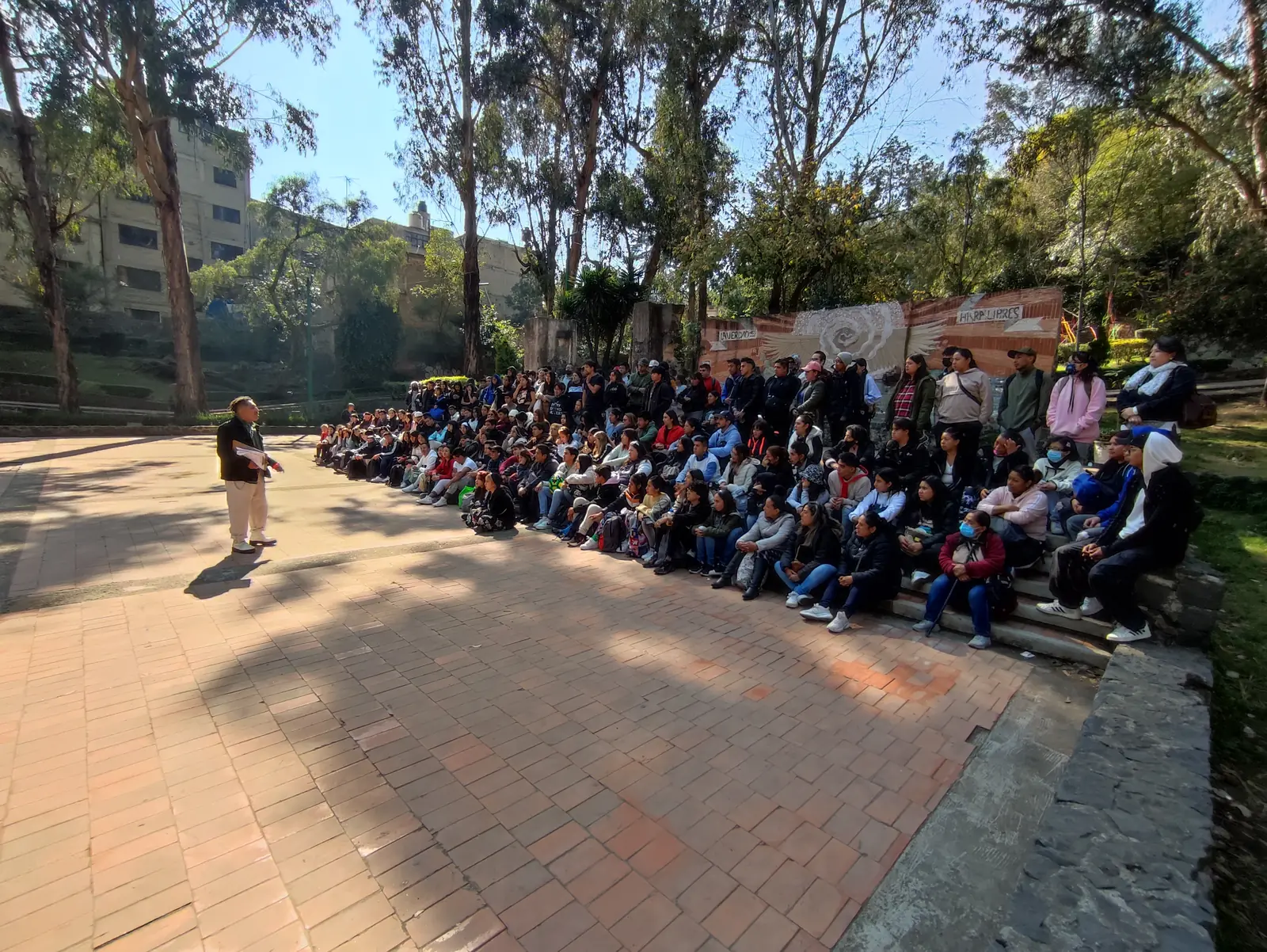 Grupo de jóvenes sentad@s escuchando un taller de ESxTI al aire libre